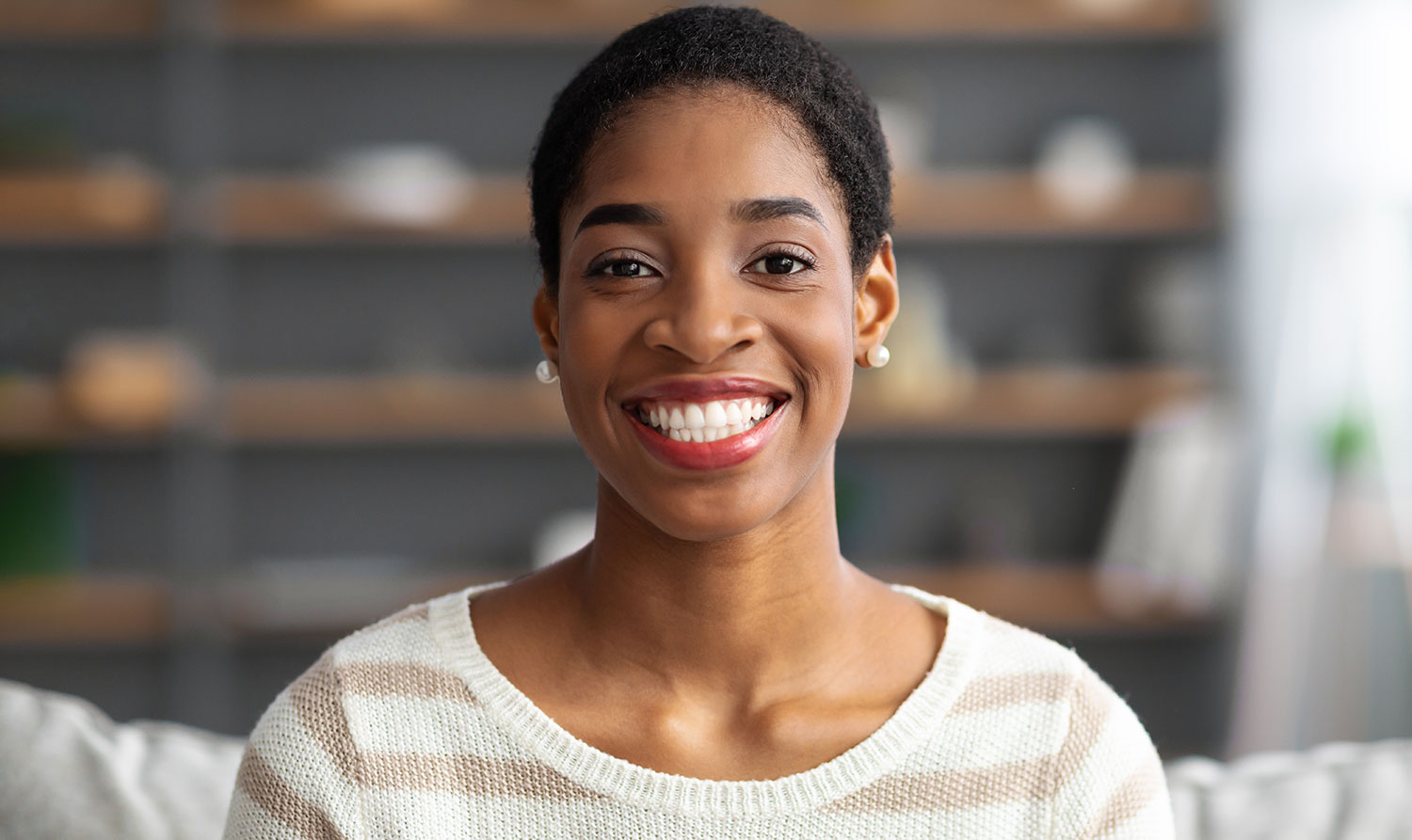 Woman smiling sitting on couch.